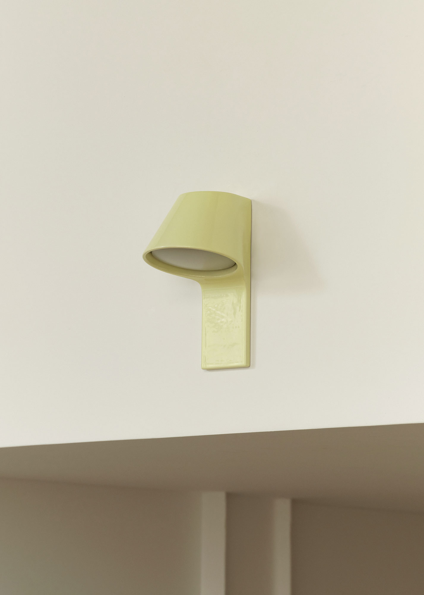 A yellow wall lamp mounted on a white wall