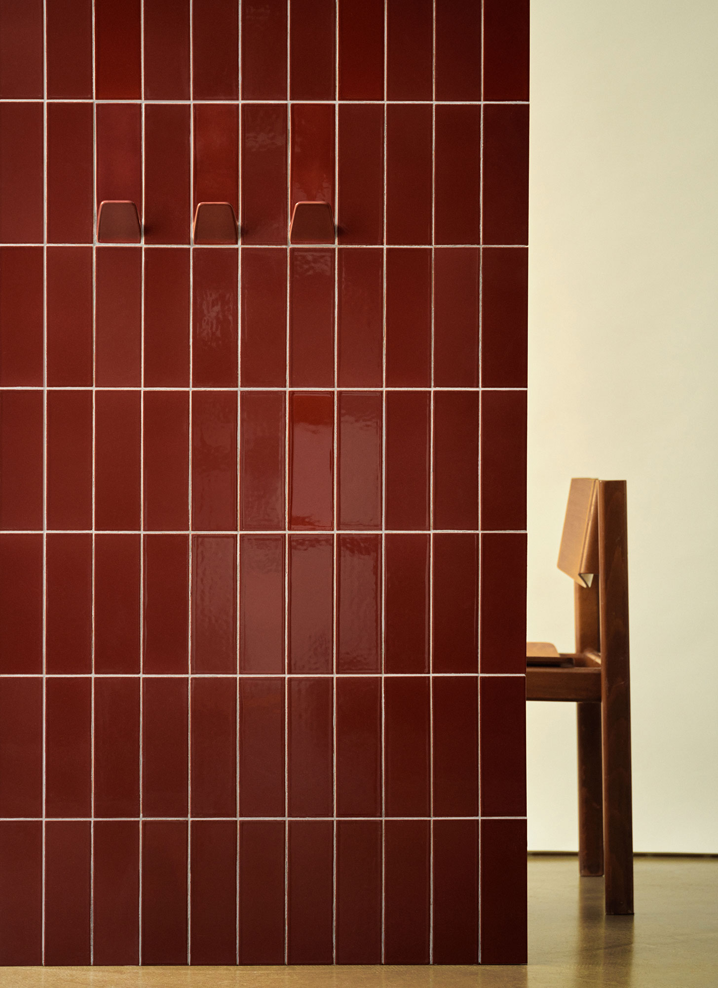 A solide rosewood wall integrating plain tiles and hook with a chair in the background